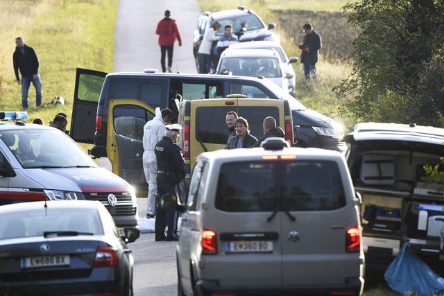 <p>Austrian police are seen near the Austrian-Hungarian border where two refugees were discovered dead inside the yellow van pictured. </p>