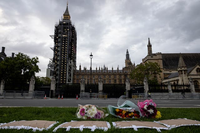 <p>Floral tributes are left in Parliament Square for Sir David Amess MP</p>