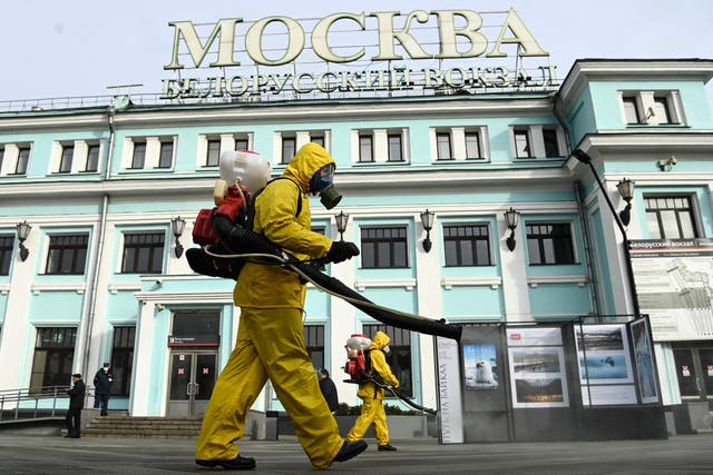 <p>Workers from Russia’s Emergencies Ministry, wearing protective gear, disinfect Moscow’s Belorussky railway station earlier this week</p>