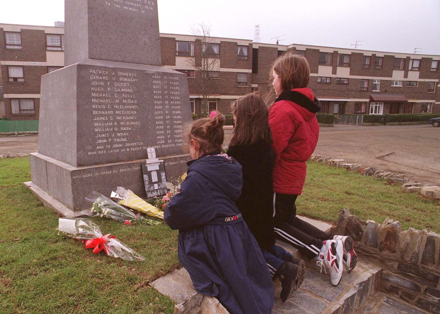 Three youngsters lay flowers at the Bloody Sunday memorial in February 1997