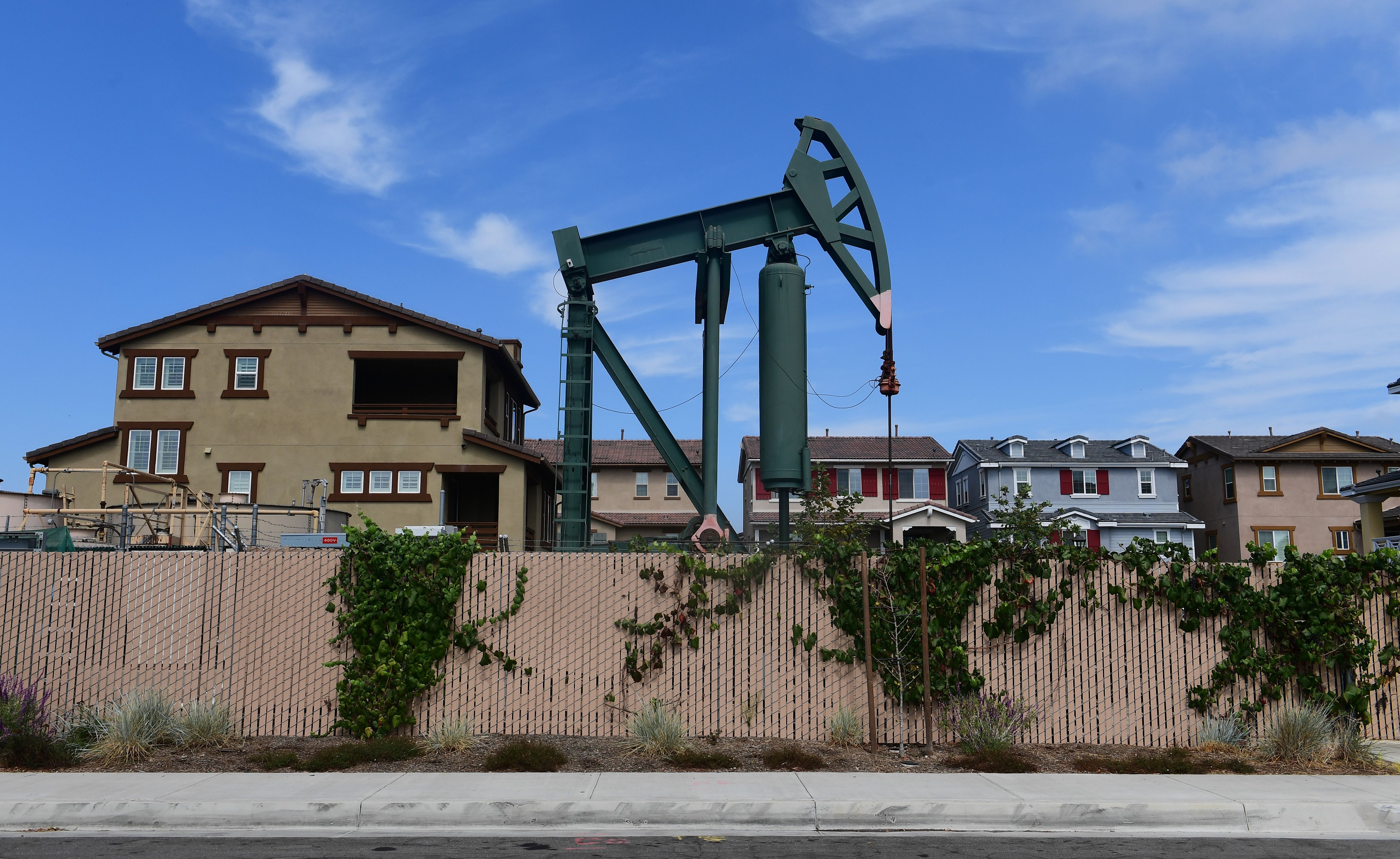 A pumpjack stands out among homes in residential Signal Hill, south of Los Angeles, California, on September 25, 2019 where oil has been pumped since the 1920's.