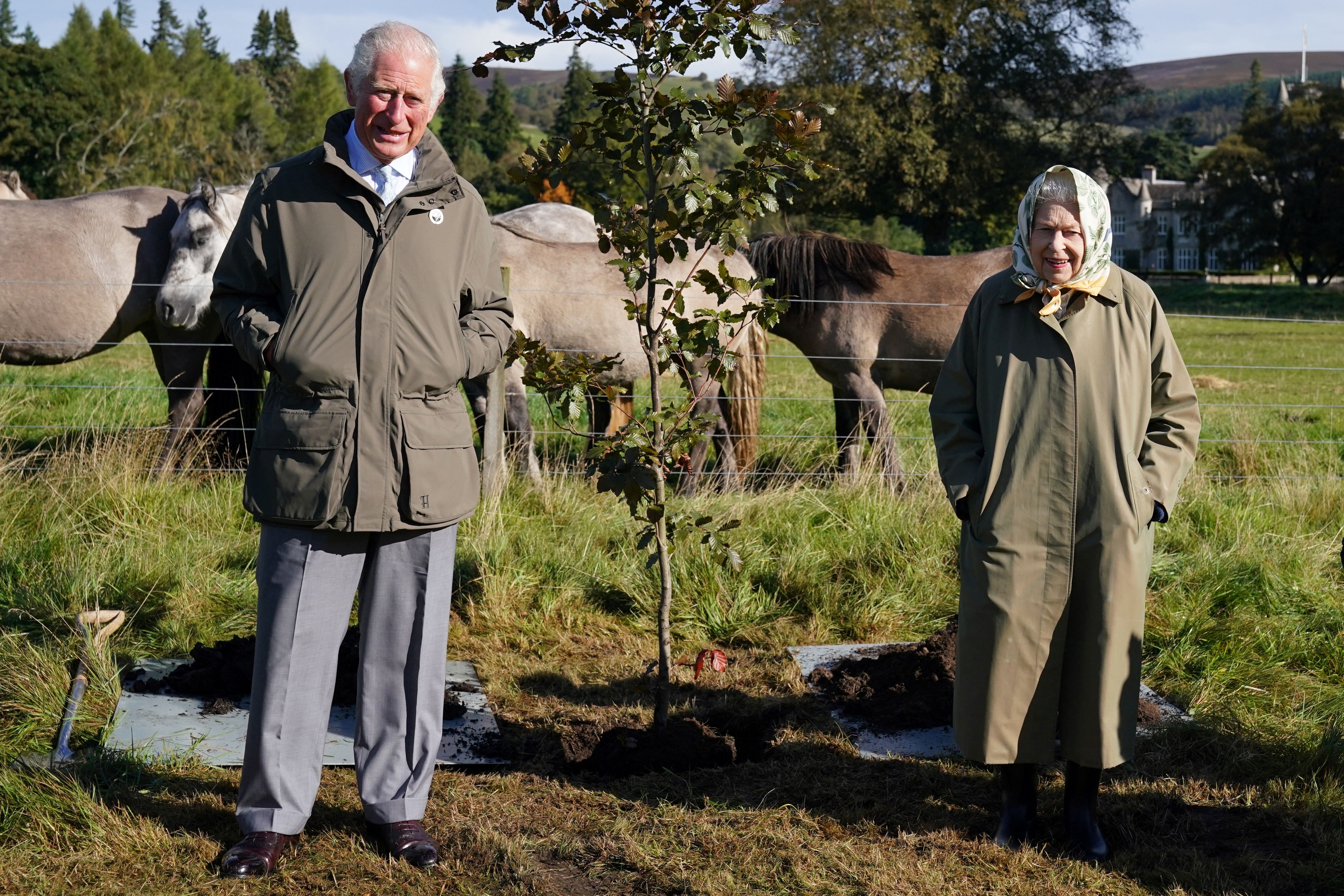 Queen Elizabeth II and Britain's Prince Charles, Prince of Wales pose alongside the tree which they planted to mark the start of the official planting season for the Queen's Green Canopy (QGC) at the Balmoral Cricket Pavilion, Balmoral Estate in Scotland in October