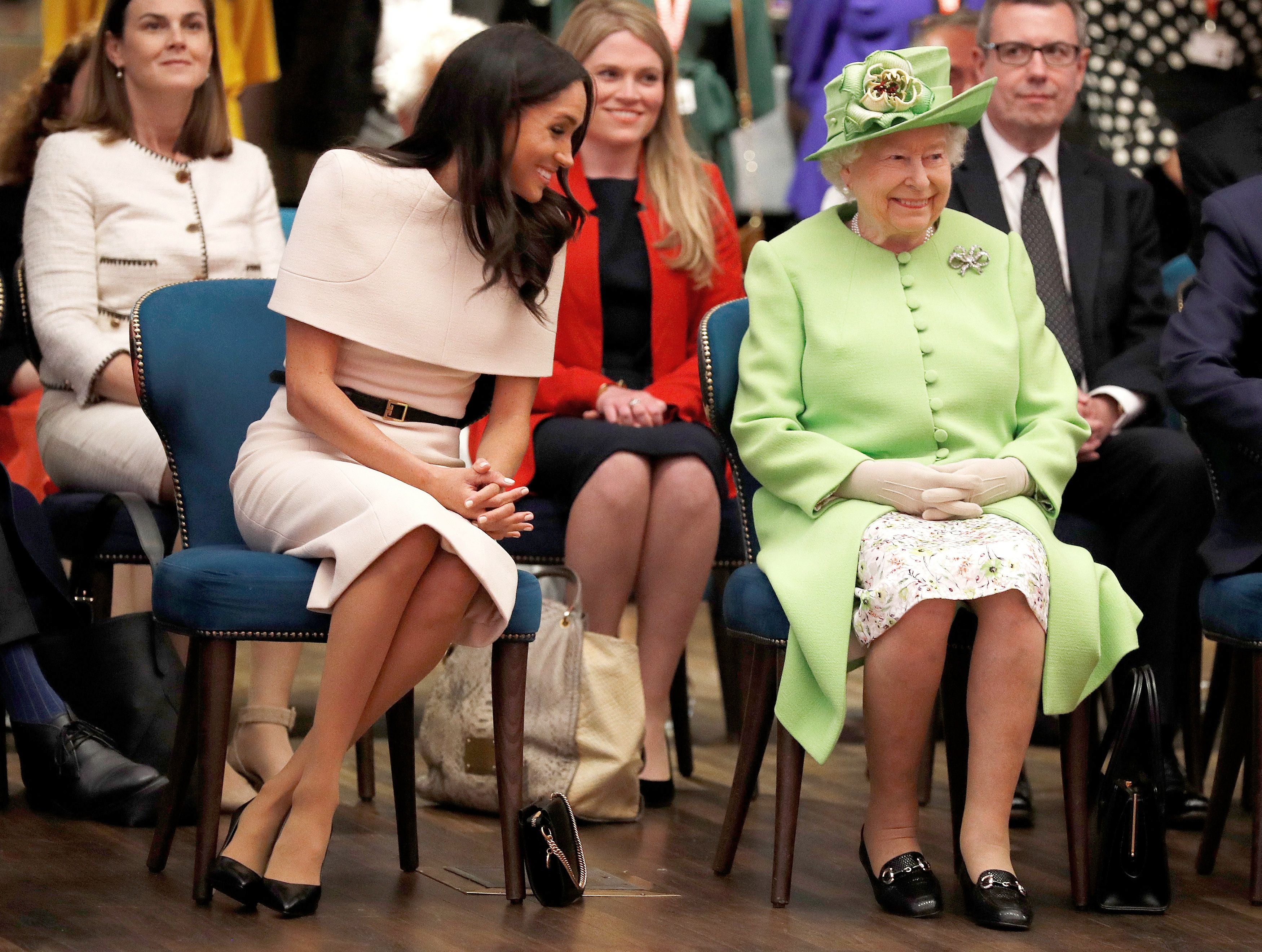 Queen Elizabeth II and Meghan, Duchess of Sussex gesture during their visit to the Storyhouse in Chester, Cheshire in 2018