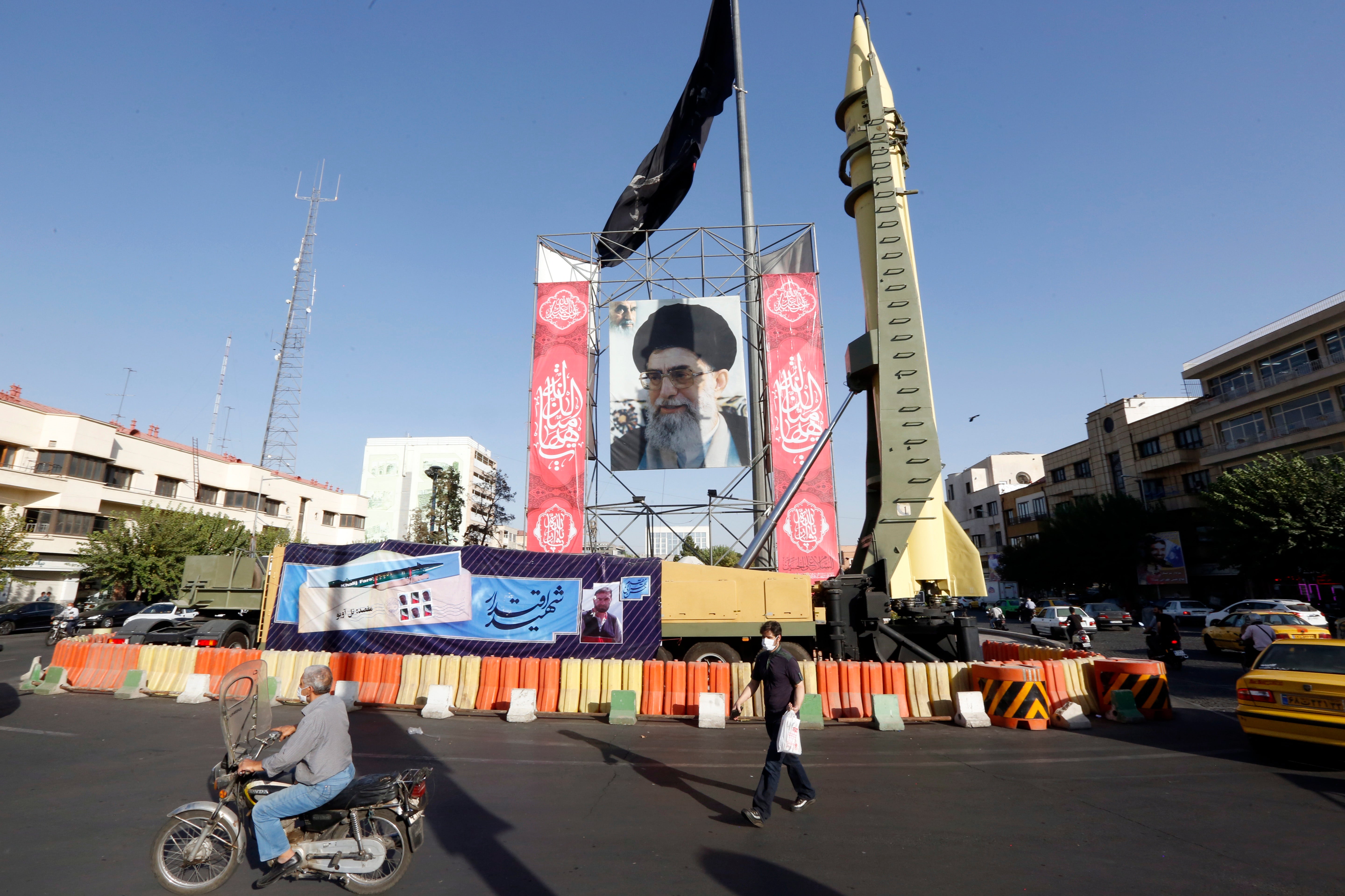 A Shahab-3 surface-to-surface missile on display next to a picture of Iranian supreme leader Ayatollah Ali Khamenei