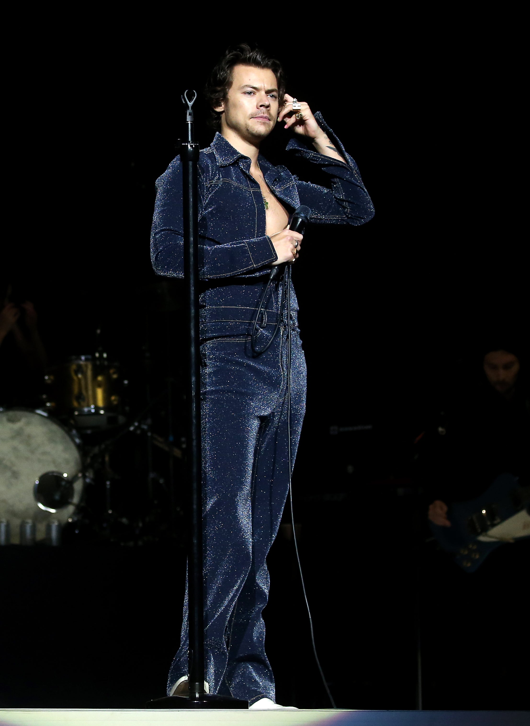 Harry Styles performing in a blue glittery jumpsuit in 2019 (Isabel Infantes/PA)
