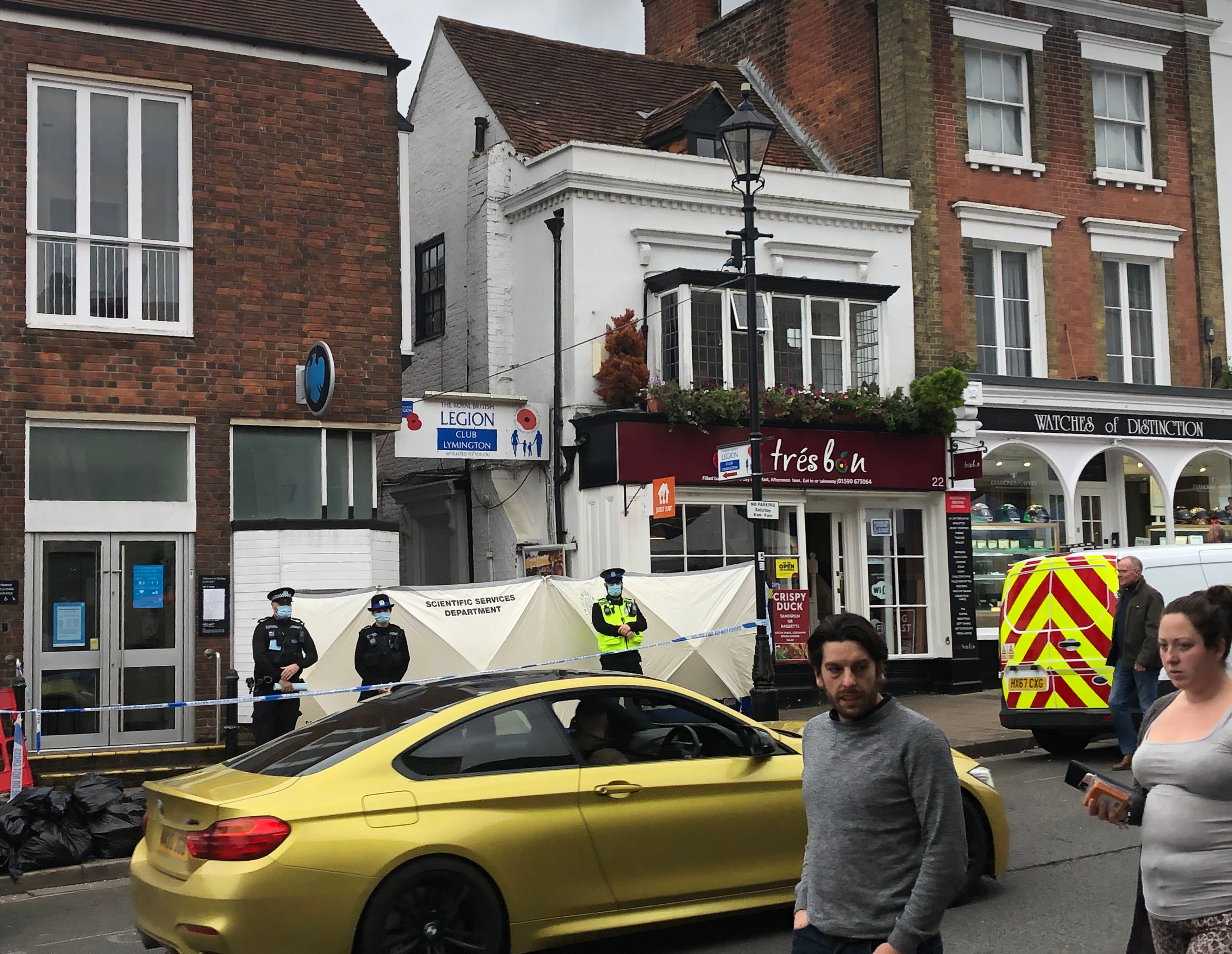 <p>Police at the scene outside the Royal British Legion on High Street in Lymington, Hampshire, where two men and a woman were found with stab wounds on Friday</p>