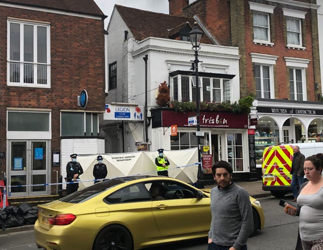 <p>Police at the scene outside the Royal British Legion on High Street in Lymington, Hampshire, where two men and a woman were found with stab wounds on Friday</p>