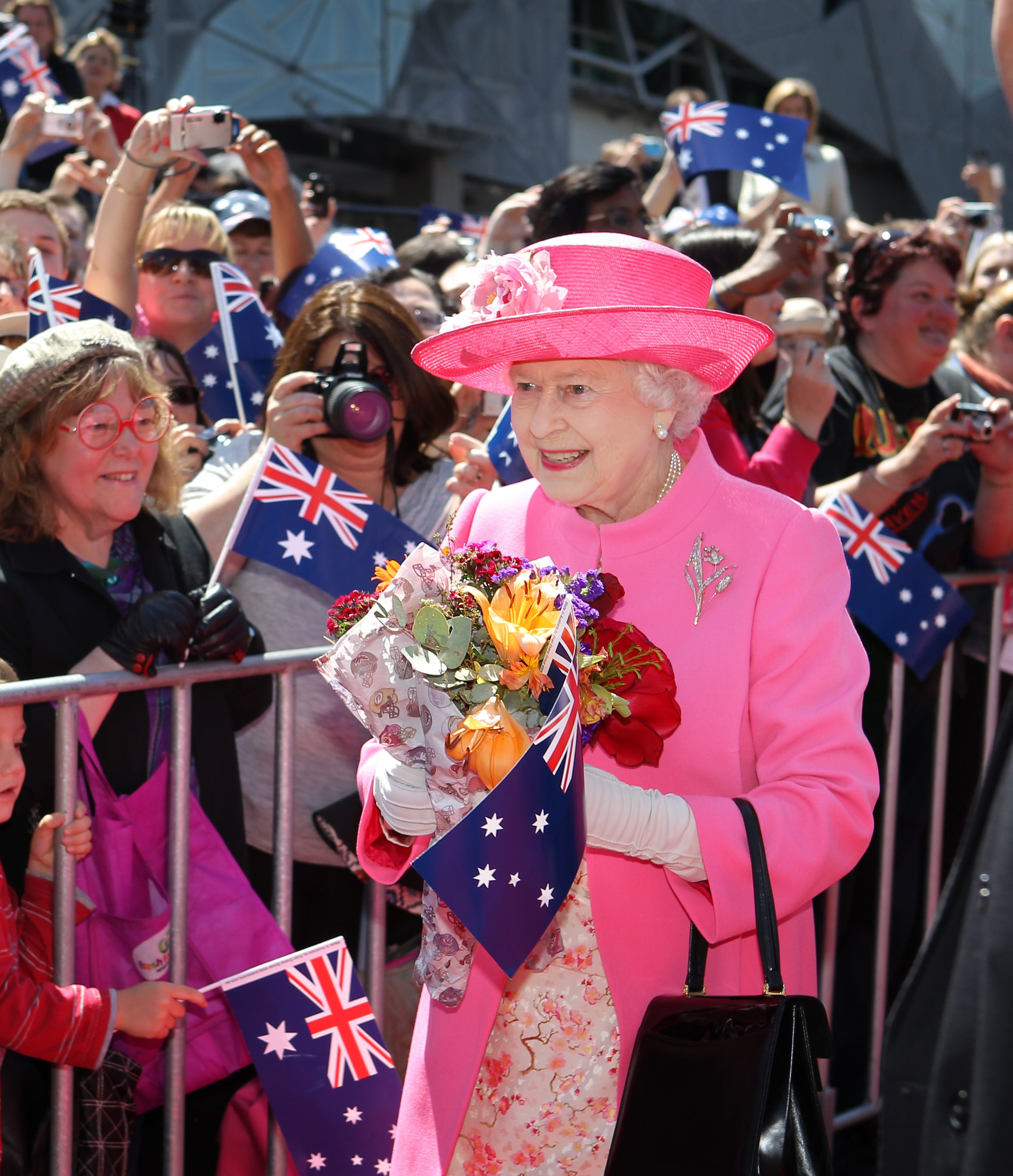 Queen Elizabeth II receives flowers from the crowd during her visit to Federation Square in downtown Melbourne, 2011