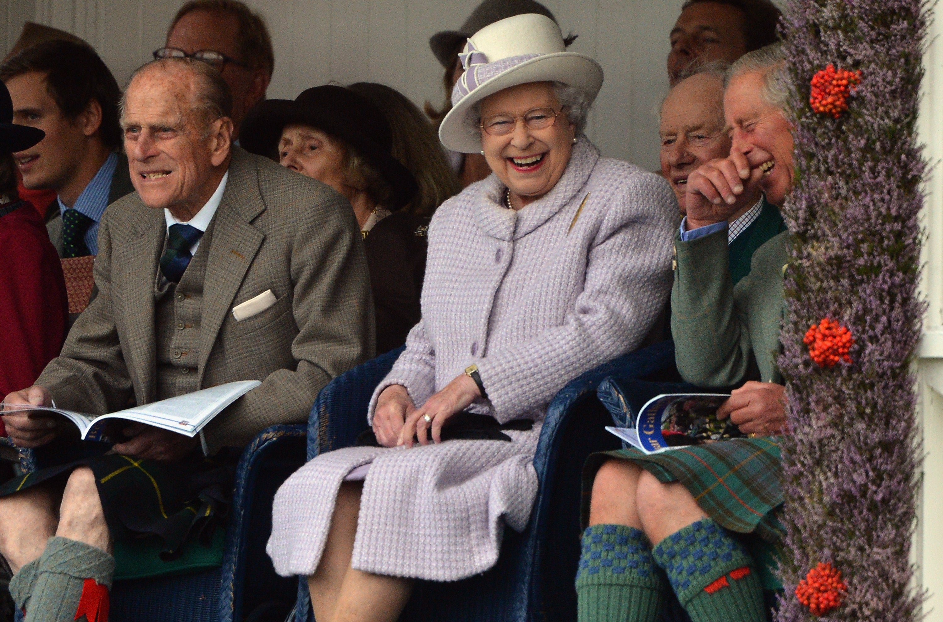 Members of Britain's royal family (front left to right) Prince Philip, Queen Elizabeth and Prince Charles cheer as competitors participate in a sack race at the Braemar Gathering in Braemar, Scotland, 2012