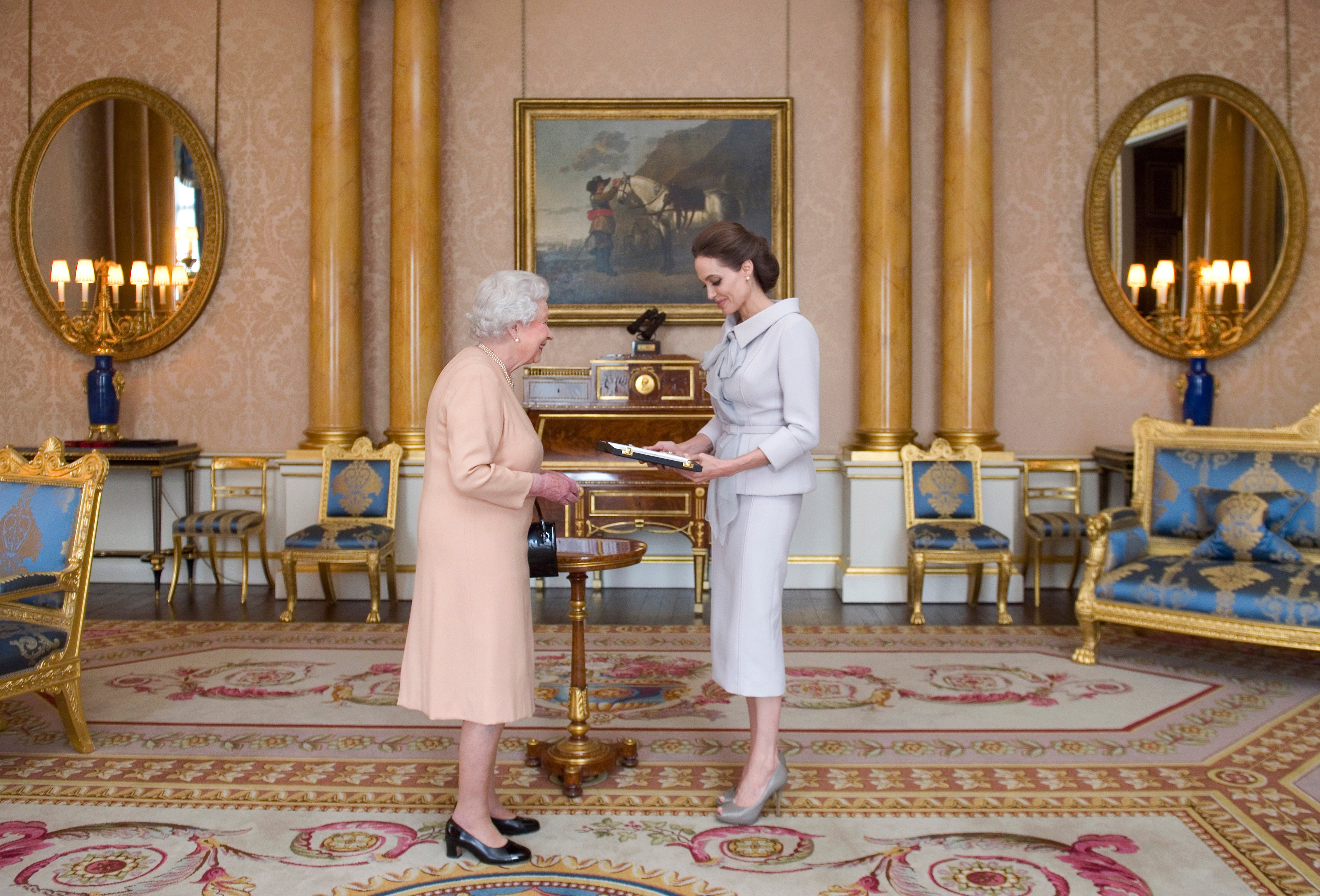 Actress Angelina Jolie is presented with the Insignia of an Honorary Dame Grand Cross of the Most Distinguished Order of St Michael and St George by Queen Elizabeth II in the 1844 Room at Buckingham Palace, 2014