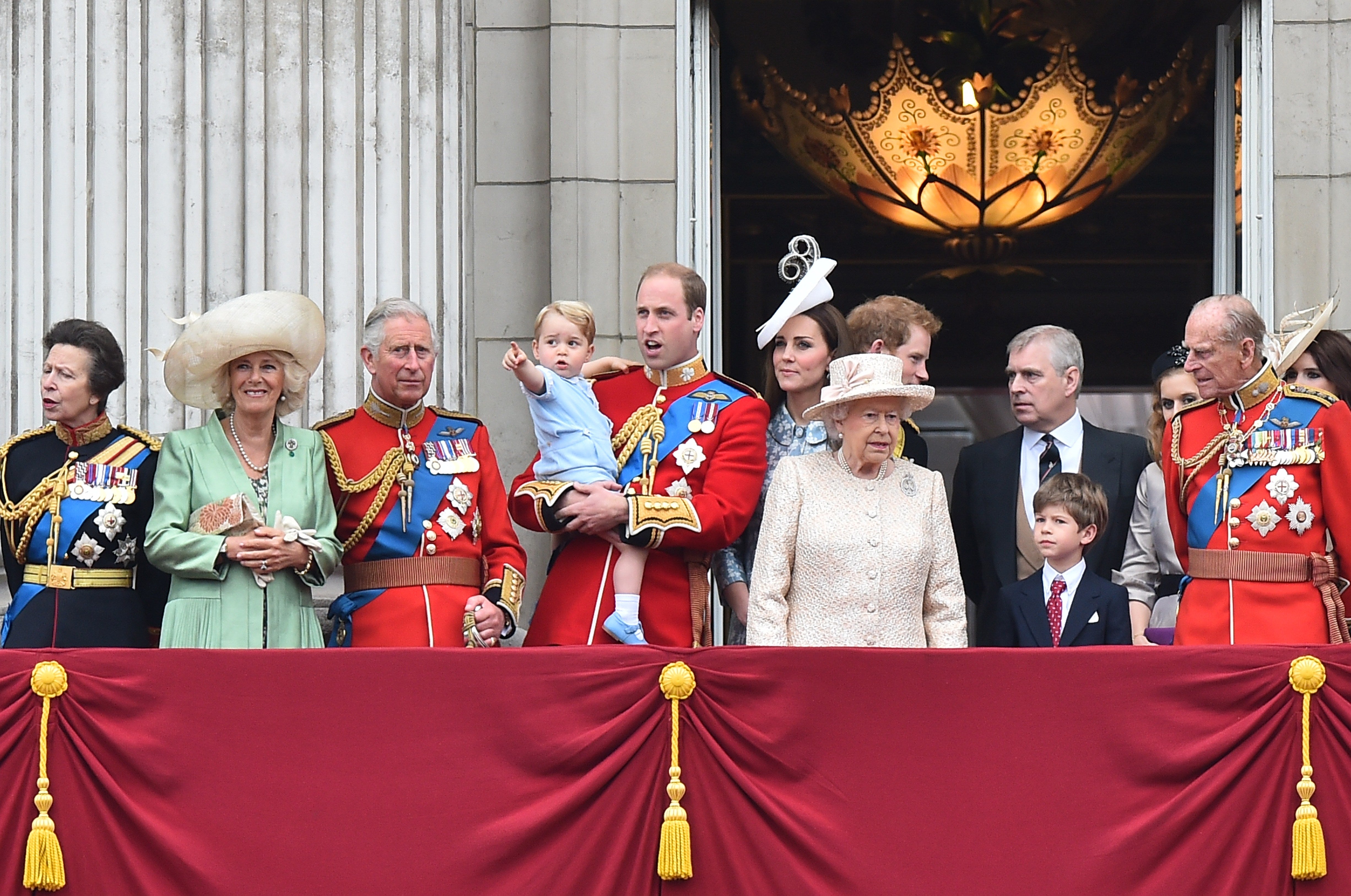 (L-R) Britain's Princess Anne, Princess Royal, Camilla, Duchess of Cornwall, Prince Charles, Prince of Wales, Prince William, Duke of Cambridge holding his son Prince George of Cambridge, Catherine, Duchess of Cambridge, Queen Elizabeth II, Prince Harry (back), Prince Andrew, Duke of York (back), James, Viscount Severn (front), Princess Beatrice of York (back), Prince Philip, Duke of Edinburgh and Princess Eugenie of York (back) stand on the balcony of Buckingham Palace waiting to view the fly-past during the Queen's Birthday Parade, 'Trooping the Colour,' in London, 2015