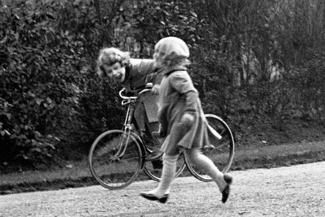 <p>Princess Elizabeth on a tricycle in the park</p>