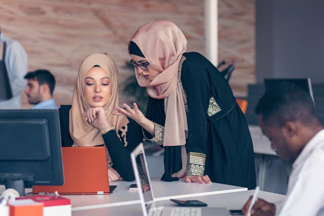 <p>Two woman with hijab working on laptop in office</p>