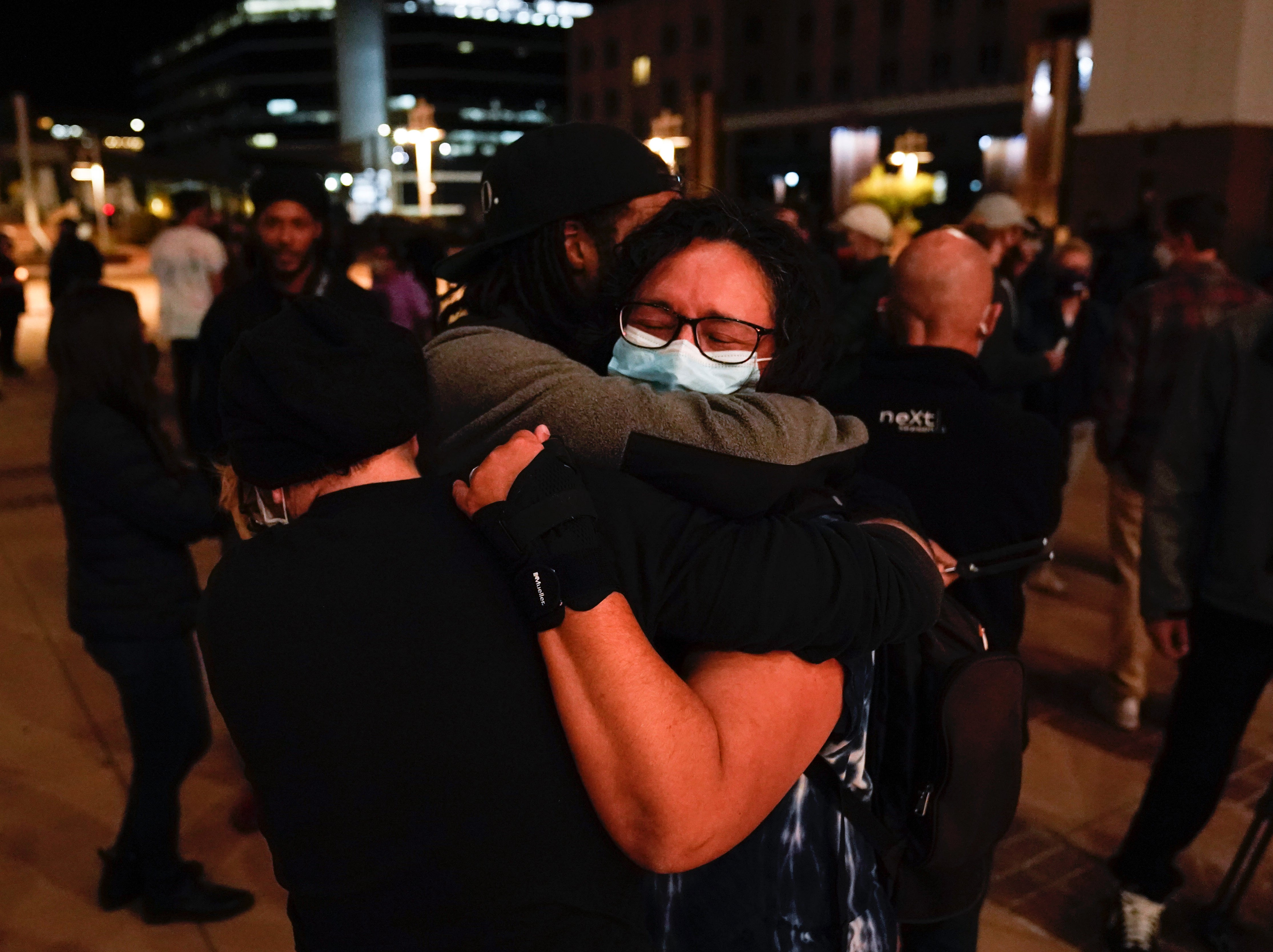 Film industry workers comfort one another at a vigil for Halyna Hutchins