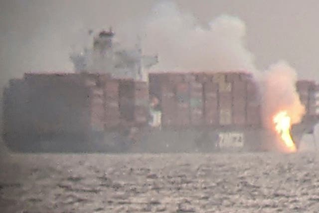 <p>Fire cascades down from the deck of the container ship ZIM Kingston into the waters off the coast of Victoria, British Columbia, Canada, October 23, 2021, as seen through a pair of binoculars, in this image obtained via social media. SURFRIDER FOUNDATION CANADA via REUTERS   </p>