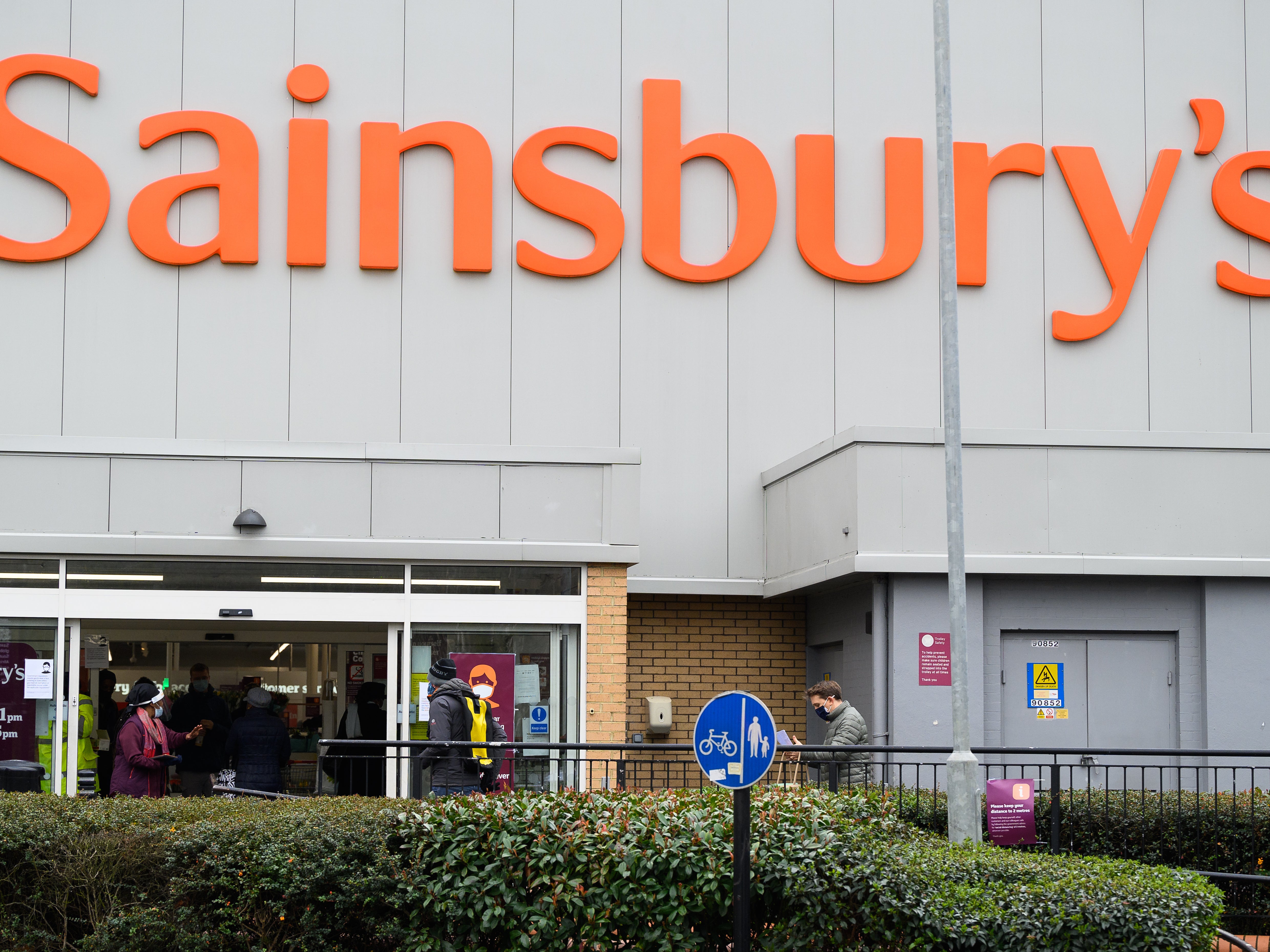 Los clientes hacen cola fuera de la sucursal de Brixton de Sainsbury's, en el suroeste de Londres, en enero