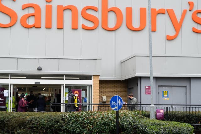 <p>Customers queue outside the Brixton branch of Sainsbury’s, in southwest London, back in January</p>