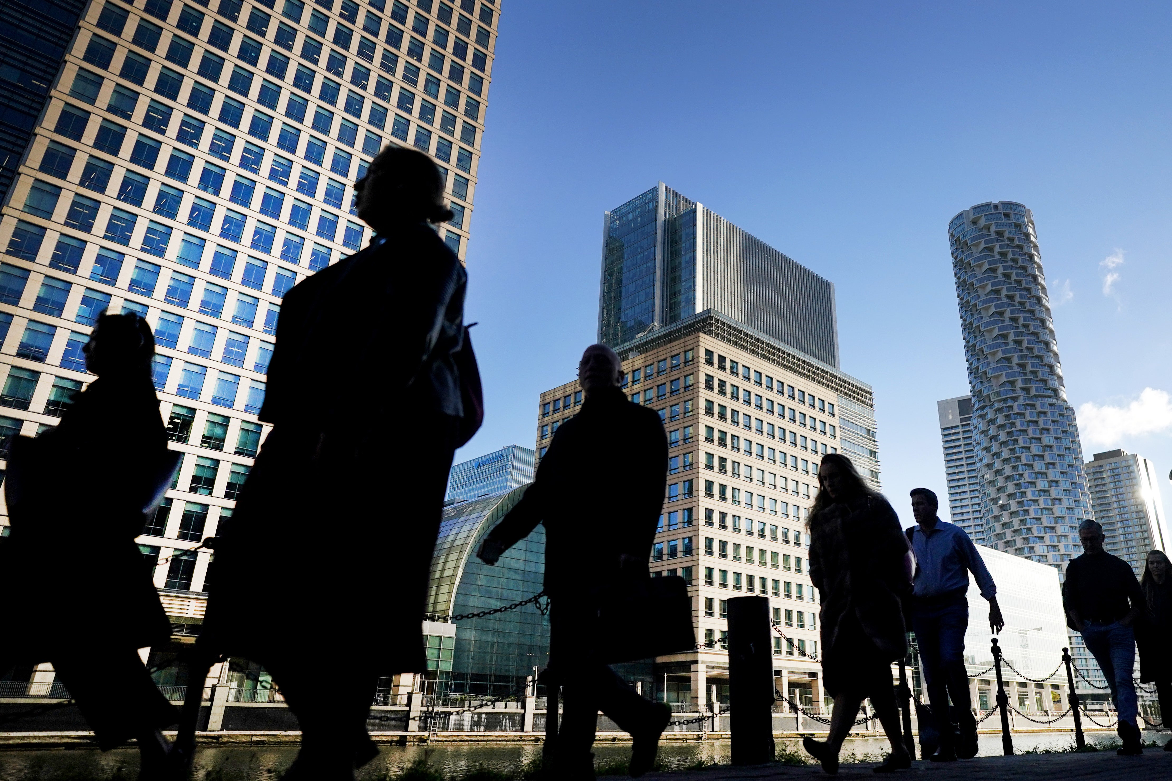 Office workers and commuters walk through Canary Wharf in London (Victoria Jones/PA)