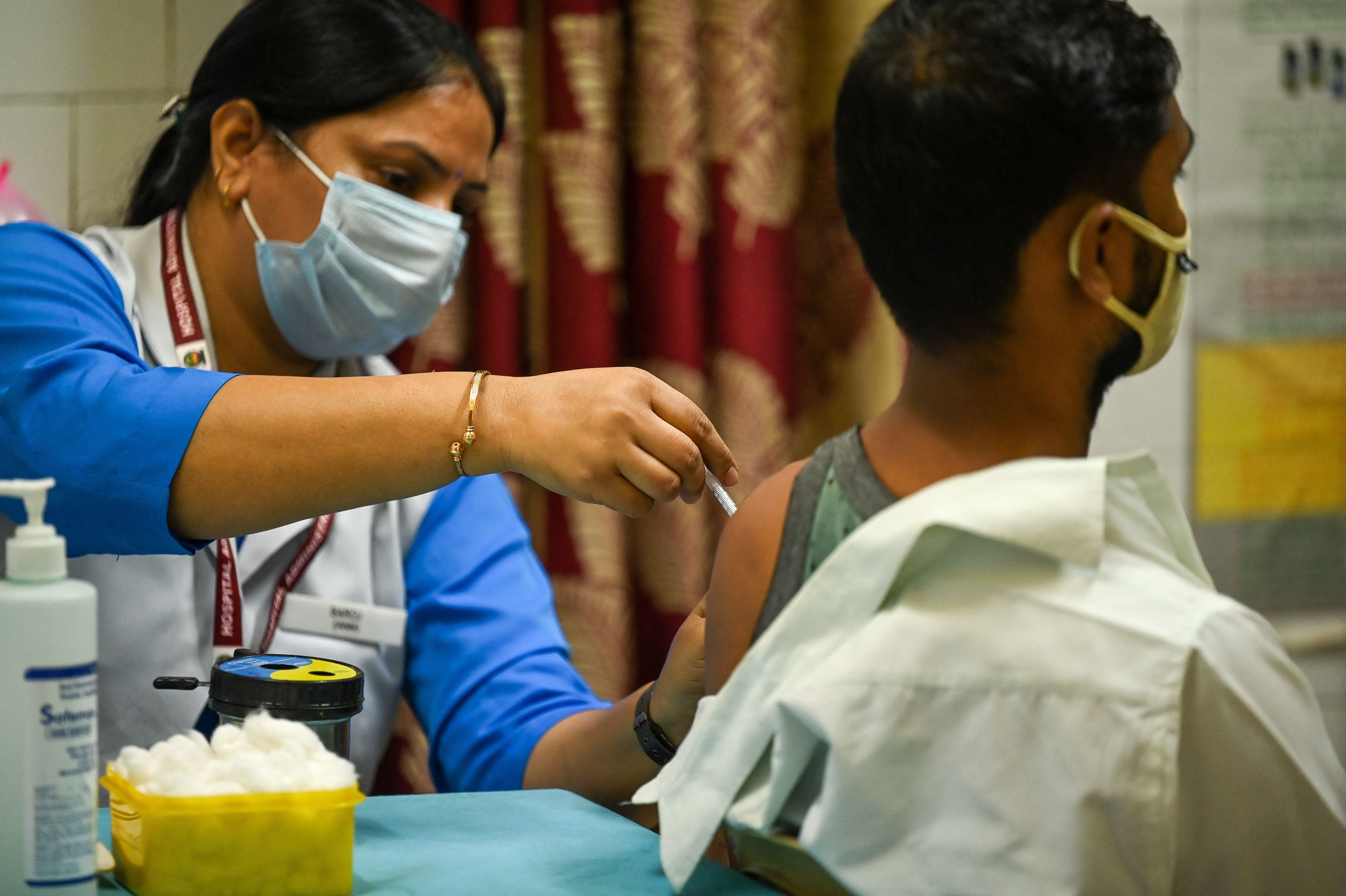 File. A health worker inoculates a man with a dose of the Covaxin vaccine against the Covid-19 coronavirus at a health centre in New Delhi on 21 October 2021