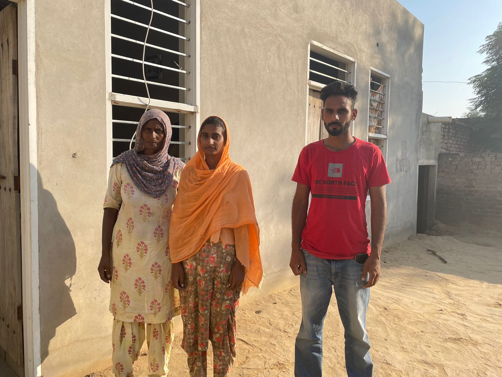 Gurvinder Singh with his mother Shinder Kaur and sister Harmanpreet outside their house in Punjab’s Mansa district. Singh’s father Parma Singh, a landless labourer, died at the age of 55 in the continuing Indian farmers’ protests