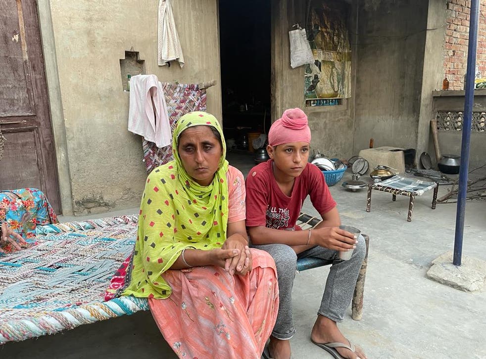 <p>Manjeet Kaur pictured here with her son, 14, at their home in Bathinda district in northern India. Kaur’s husband Dhanna Singh is one of the hundreds of farmers who have died in the ongoing farmers’ protests against the Modi government’s three farm laws </p>