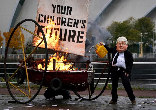 <p>Ocean Rebellion protestors set light to fake boat opposite the Cop26 conference venue </p>