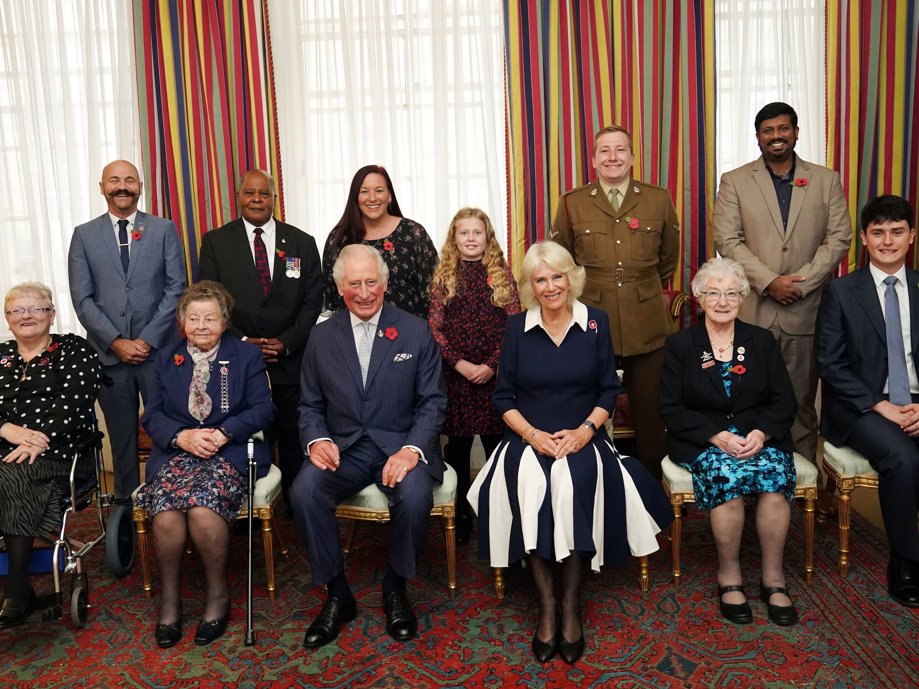 The Prince of Wales (front centre) and Duchess of Cornwall (third right front), with ten Royal British Legion (RBL) Poppy Appeal collectors: (front row left-right) Lesleyanne Gardner, Jill Gladwell, Vera Parnaby, Billy Wilde, and (back row left-right) David Kelsey, Andy Owens, Anne-Marie Cobley, Maisie Mead, Lance Corporal Ashley Martin and Mirza Shahzad at Clarence House, London, during the official launch of the centenary poppy appeal
