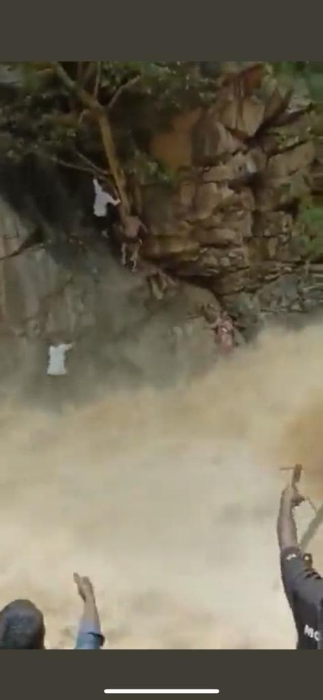 <p>A woman and her child are seen in a viral video being rescued from a waterfall in the southern state of Tamil Nadu in India</p>