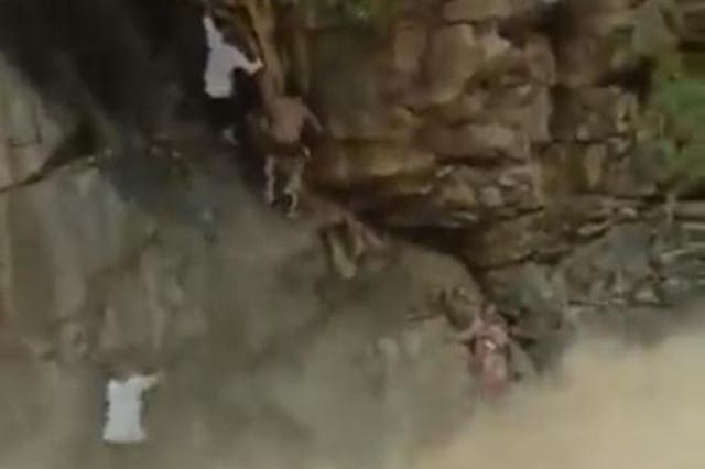 <p>A woman and her child are seen in a viral video being rescued from a waterfall in the southern state of Tamil Nadu in India</p>