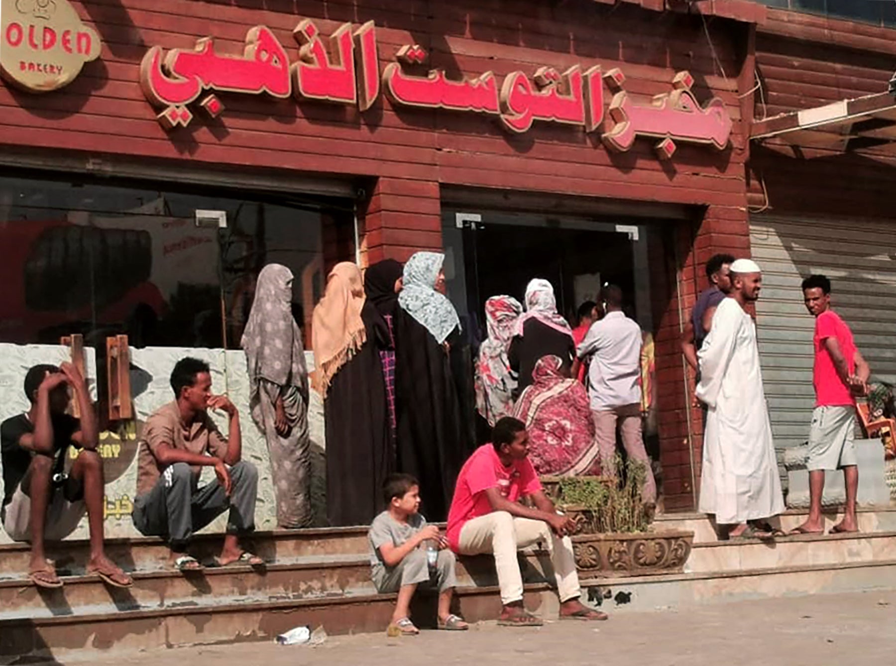 Sudanese people queue for bread outside a bakery in the capital Khartoum