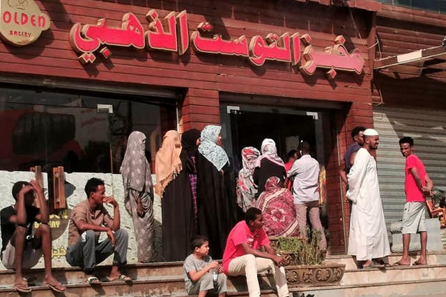 <p>Sudanese people queue for bread outside a bakery in the capital Khartoum </p>