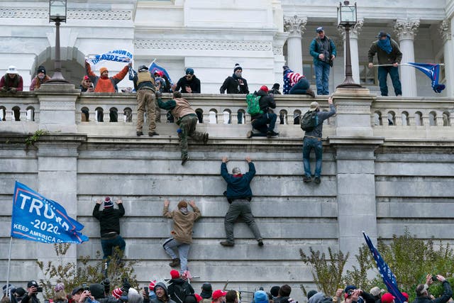 Los partidarios de Trump escalan los muros del Capitolio de los Estados Unidos el 6 de enero de 2021