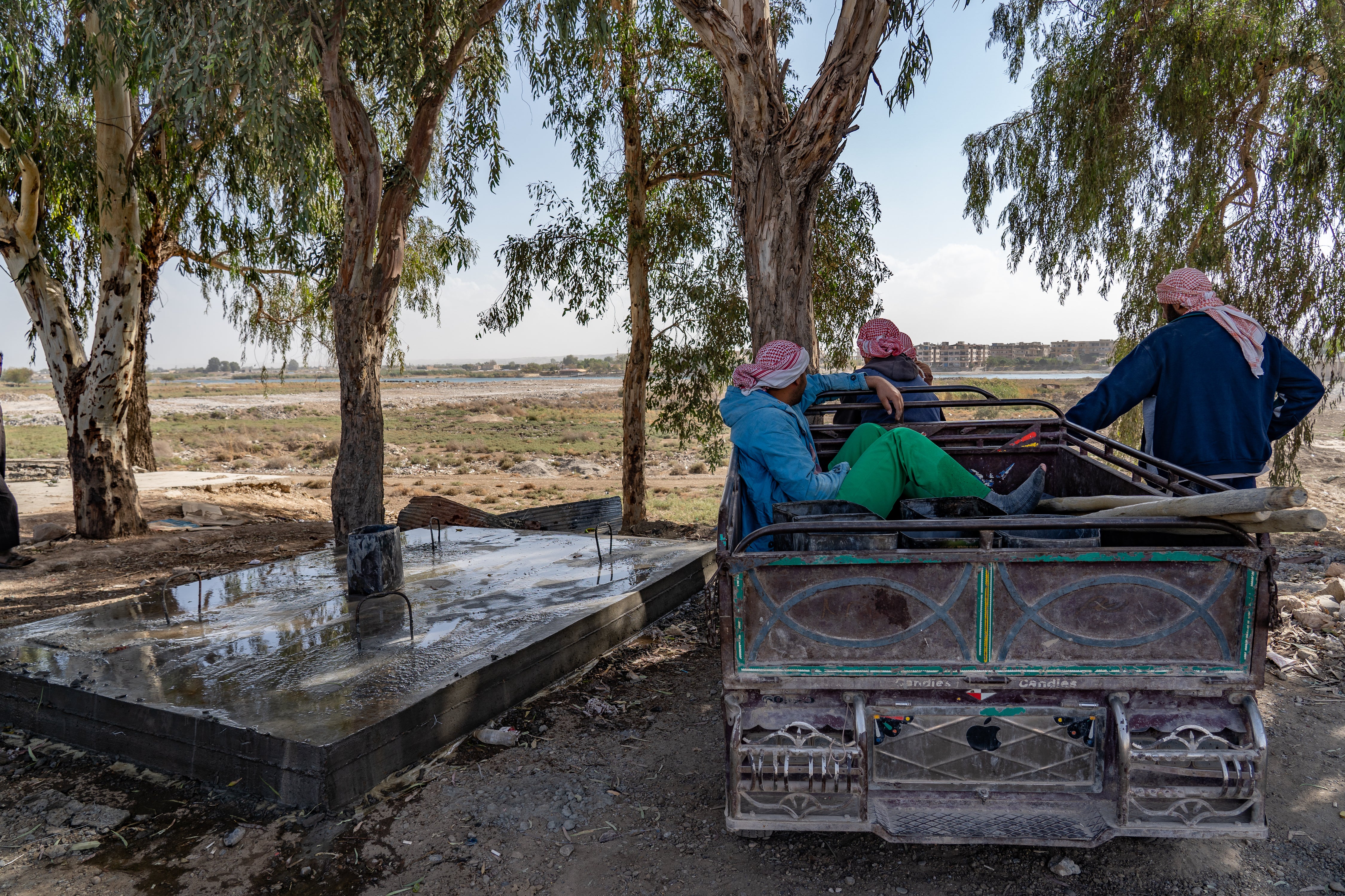 Water truckers in Raqqa look out over the dwindling Euphrates