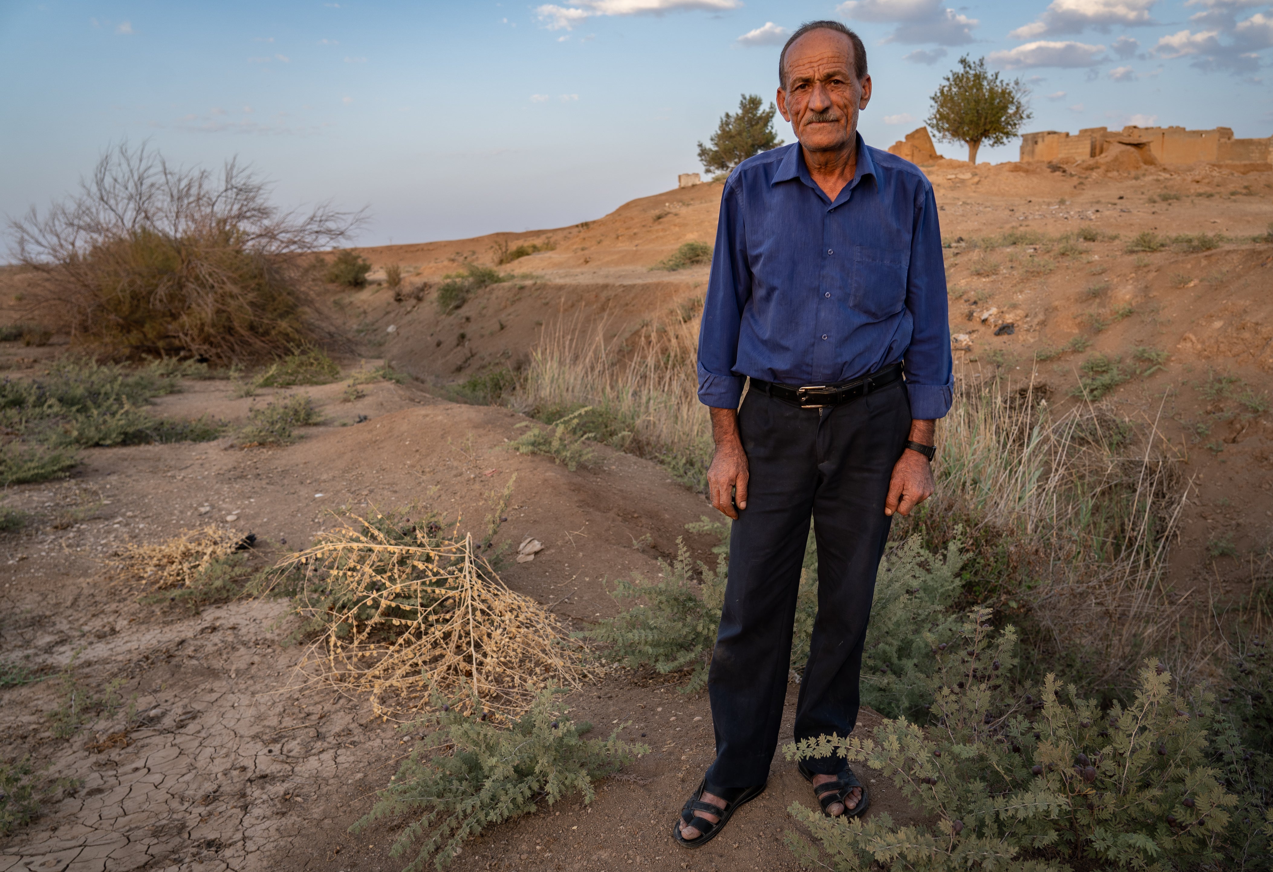 Brekha, standing by the dry Khabour River, says planting crops is a ‘gamble’