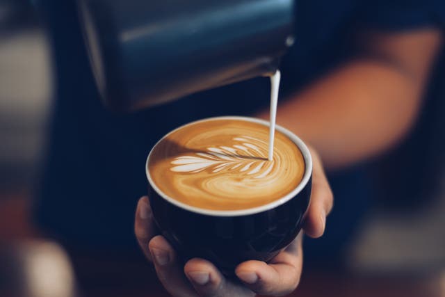 <p>A person holds a latte</p>