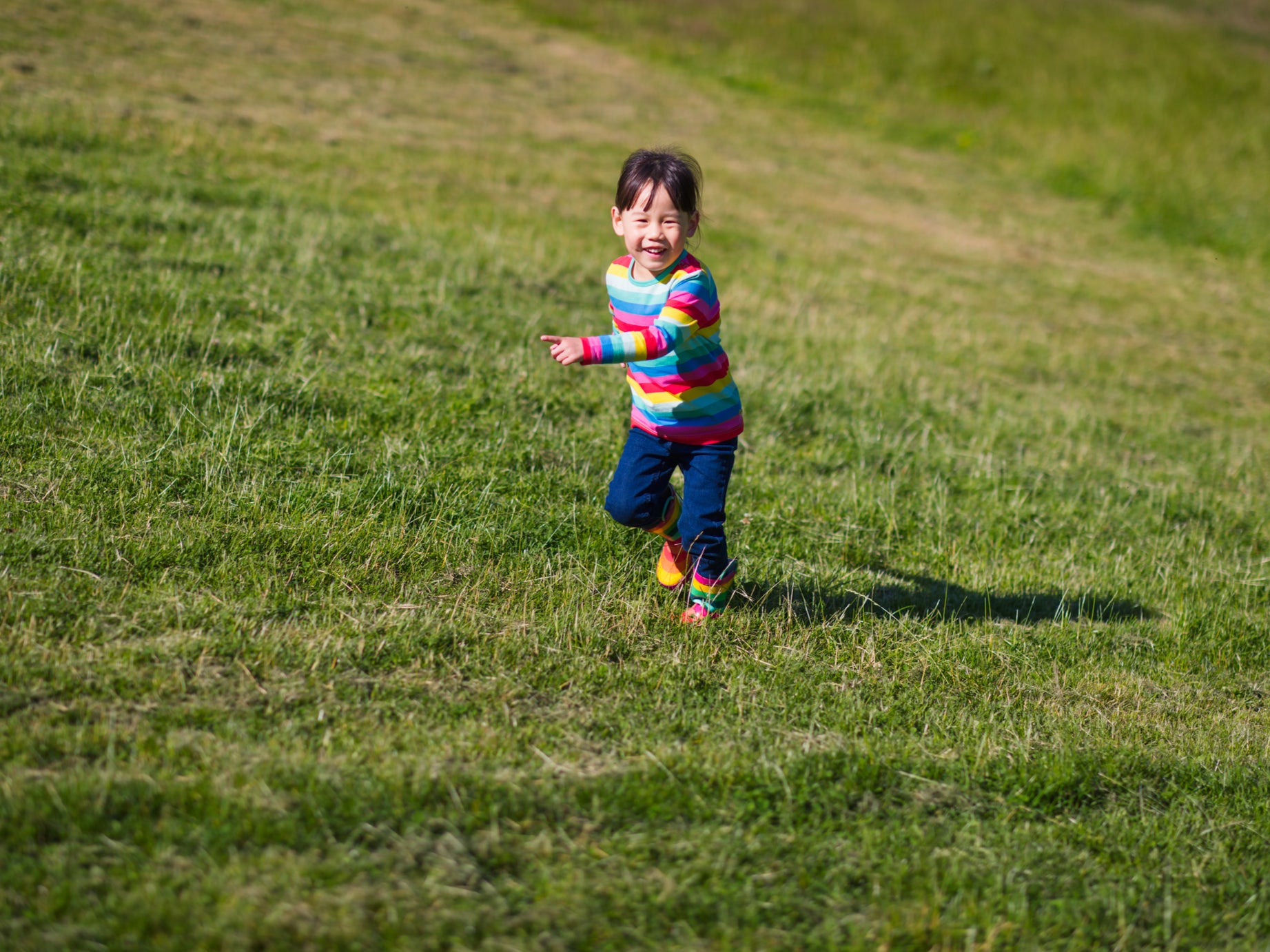 A young child runs across a field