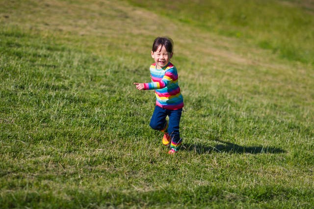 <p>A young child runs across a field</p>
