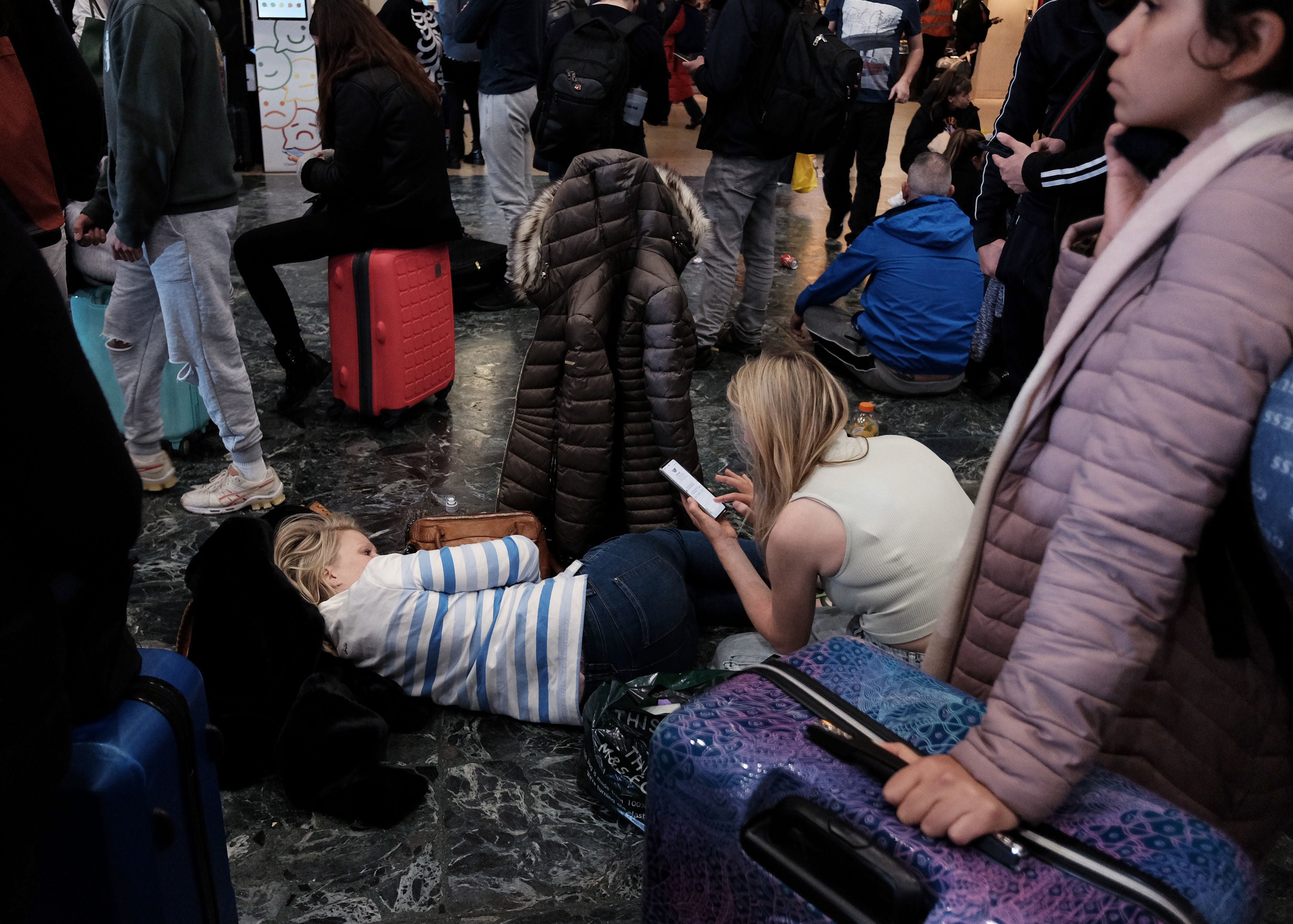 Passengers attempt to sleep on the floor at London Euston
