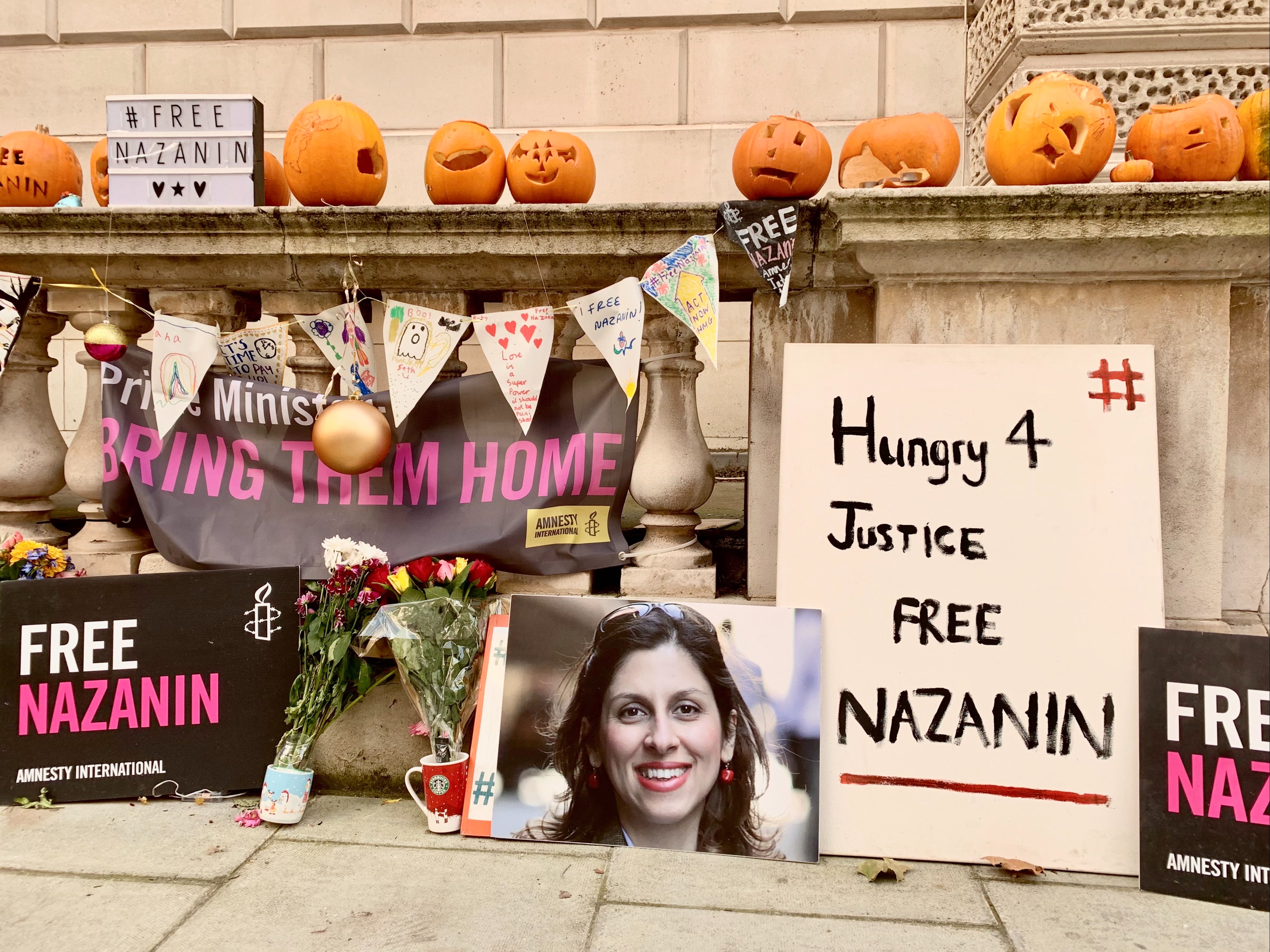 A collection of Free Nazanin-themed decor sits behind Ratcliffe, including the pumpkins he and daughter Gabriella carved for Halloween