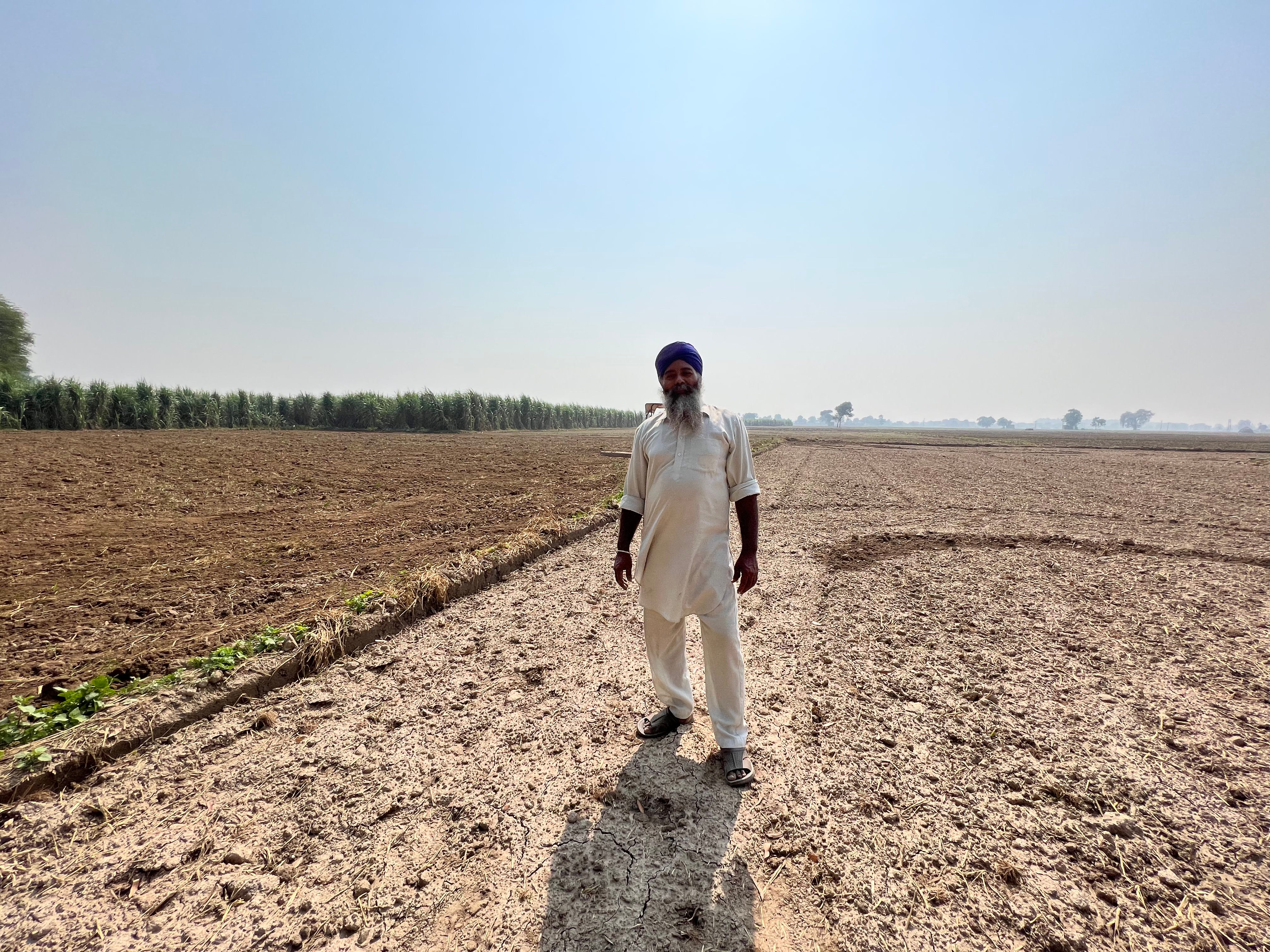 55-year-old Gurcharan Singh stands in his freshly cleared field in Haryana, India