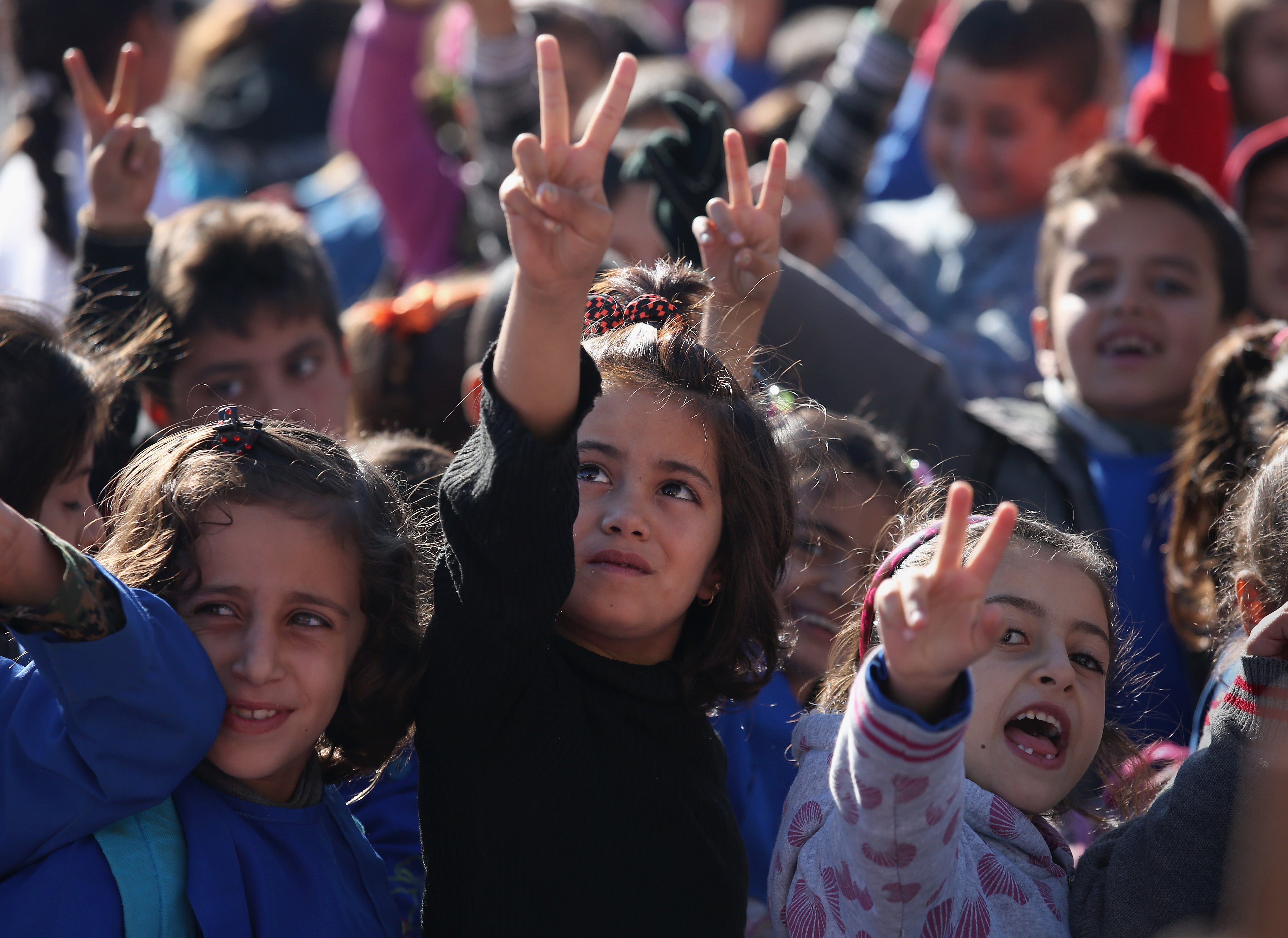 Children give the victory sign at an elementary school in Rojava on 12 November 2015