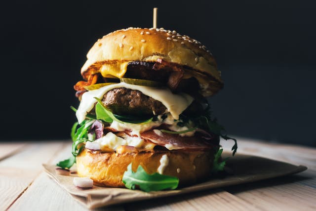 <p>A burger on wooden table</p>