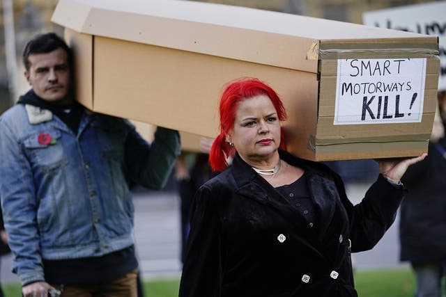 <p>Demonstrators protesting against smart motorways march with coffins across Westminster Bridge to Parliament Square in London</p>