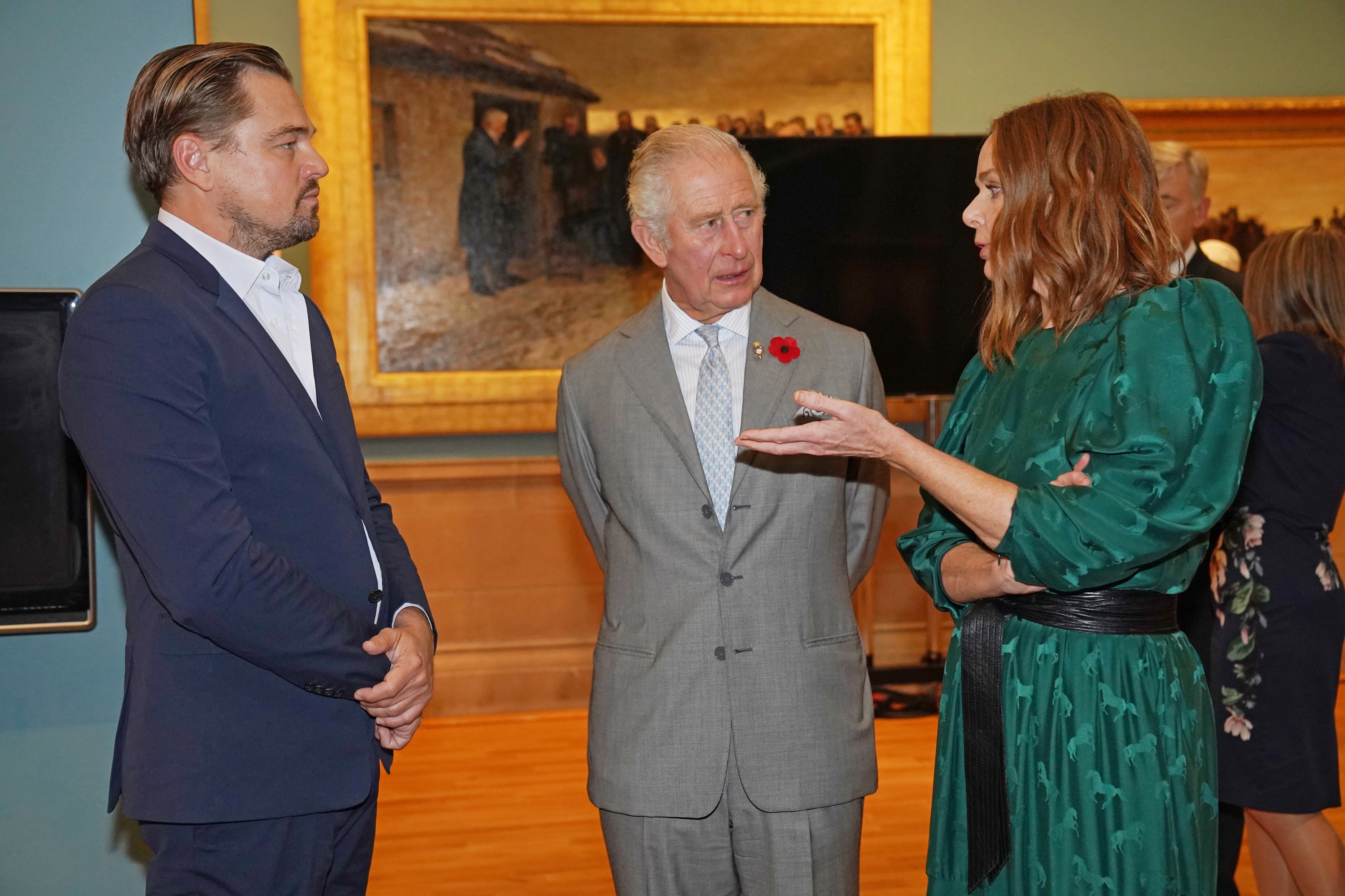 The Prince of Wales (centre) speaks with designer Stella McCartney (right) and Leonardo DiCaprio (left) as he views a fashion installation by the designer, at the Kelvingrove Art Gallery and Museum, during the Cop26 summit