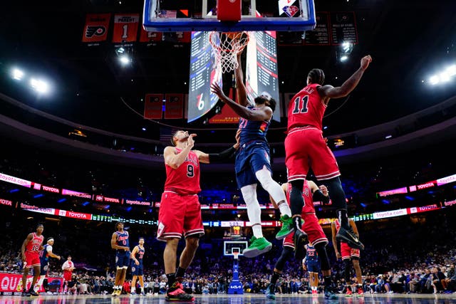 Philadelphia 76ers’ Joel Embiid (21) goes up for a dunk against Chicago Bulls’ Nikola Vucevic (9) and DeMar DeRozan (11) (Matt Slocum/AP)