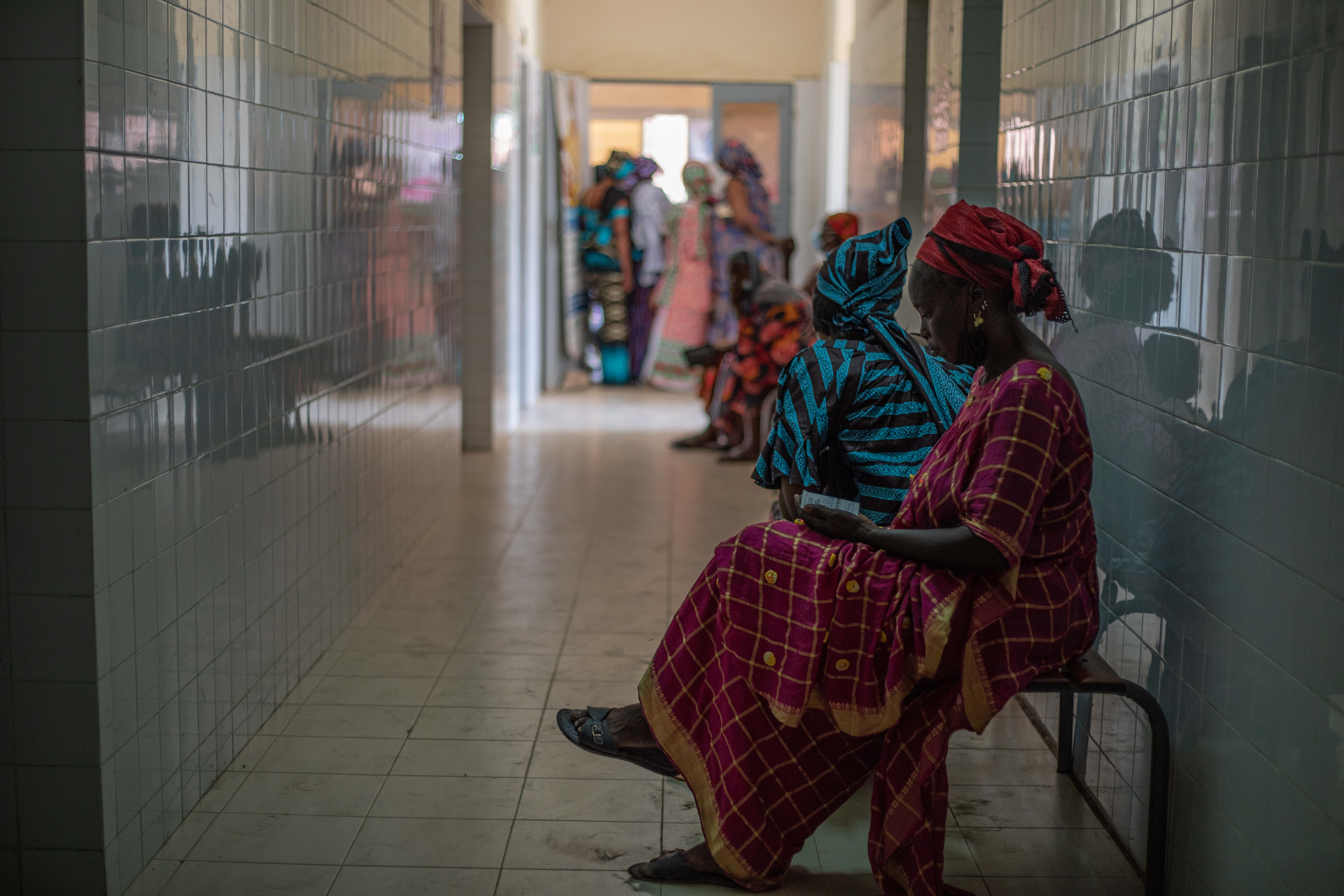 Women sit in the waiting room at the Santhie public health site in Joal-Fadiouth