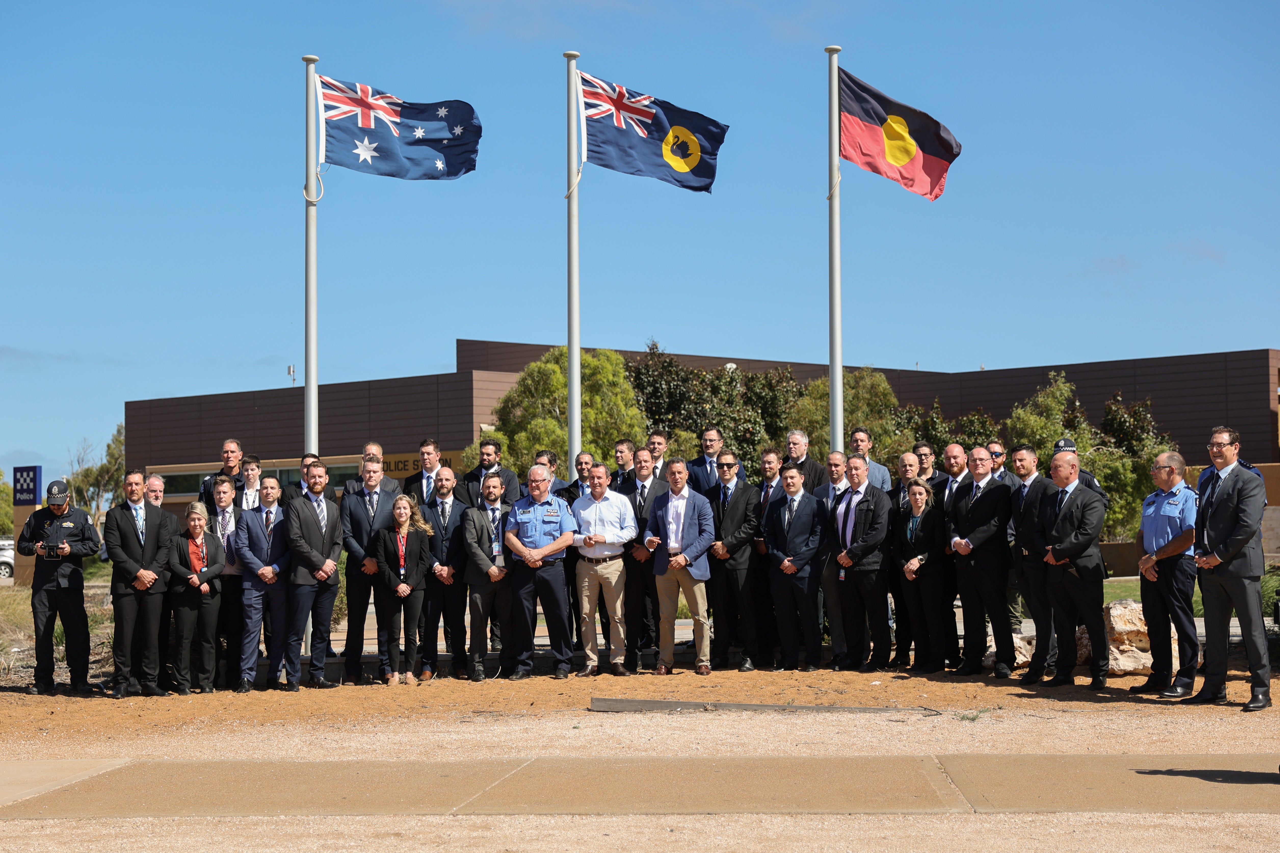 Western Australia Premiere Mark McGowan poses with police officers after speaking at a press conference in front of the Carnarvon Police Station