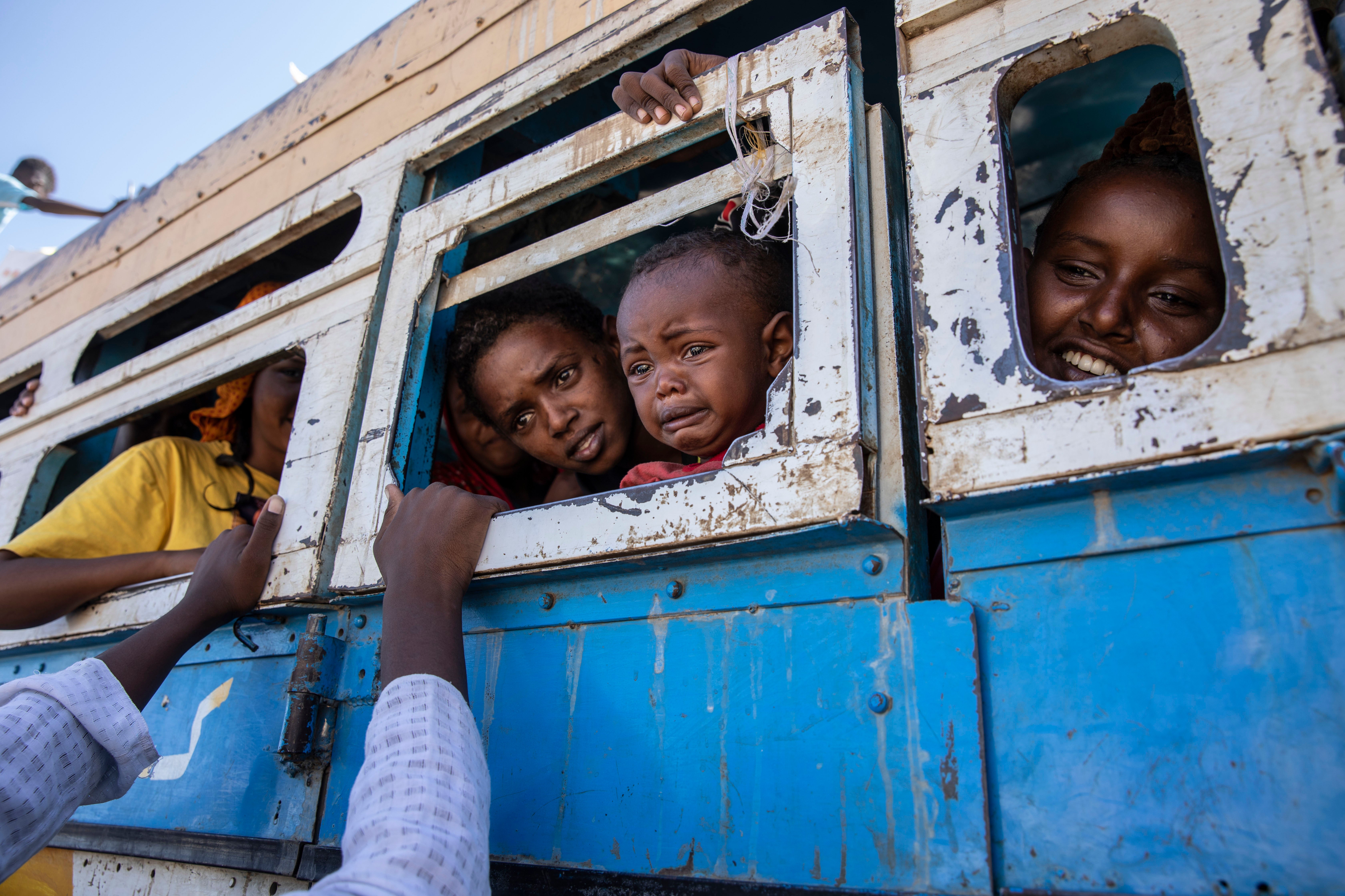 Tigray refugees who fled the conflict en route to temporary accommodation