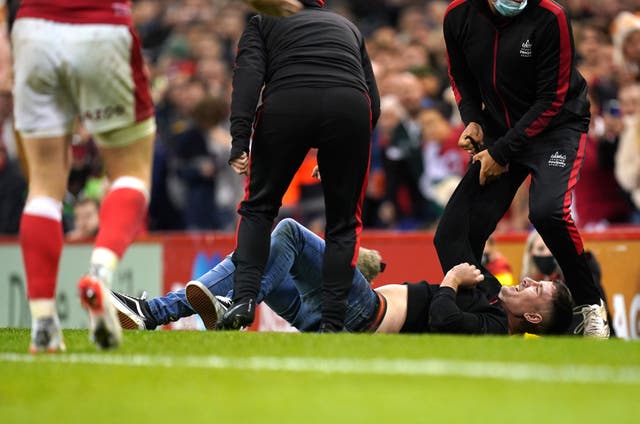 <p>A pitch invader is restrained on the field</p>