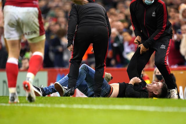 <p>A pitch invader is restrained on the field</p>